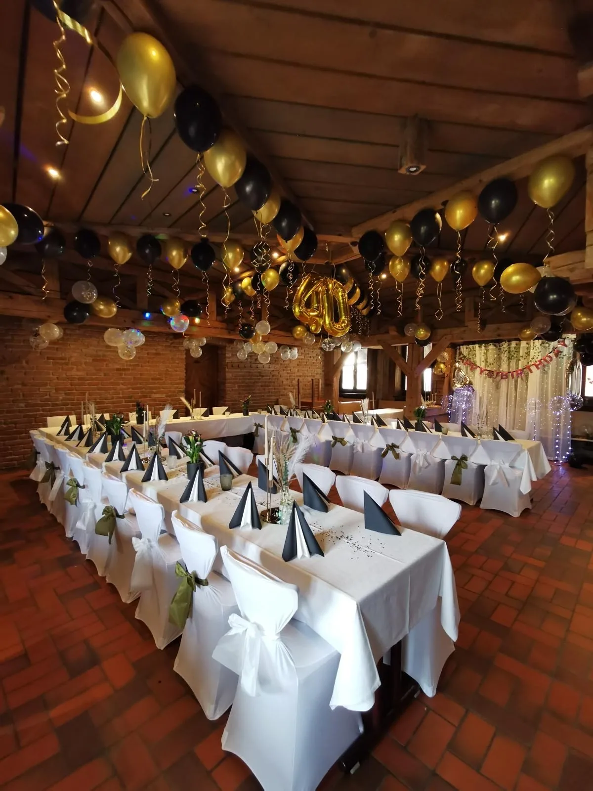 Festlich gedeckte lange Tafel mit weißen Tischdecken und Ballons