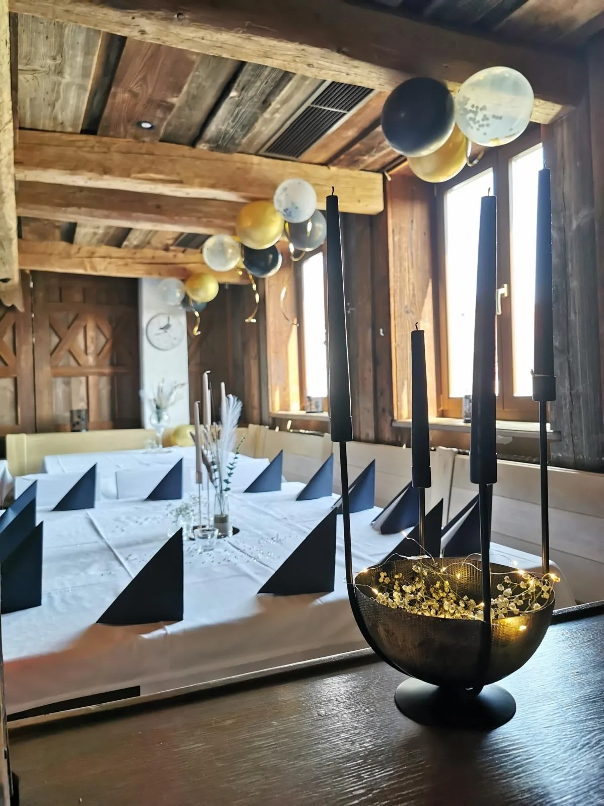 Festsaal mit eingedeckten Tischen und Kerzenleuchtern