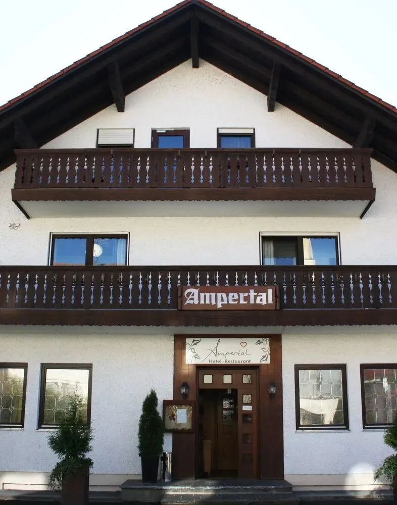 Das Hotel Restaurant Ampertal von außen: bayerisches Haus mit Holzbalkon und Ampertal-Schriftzug