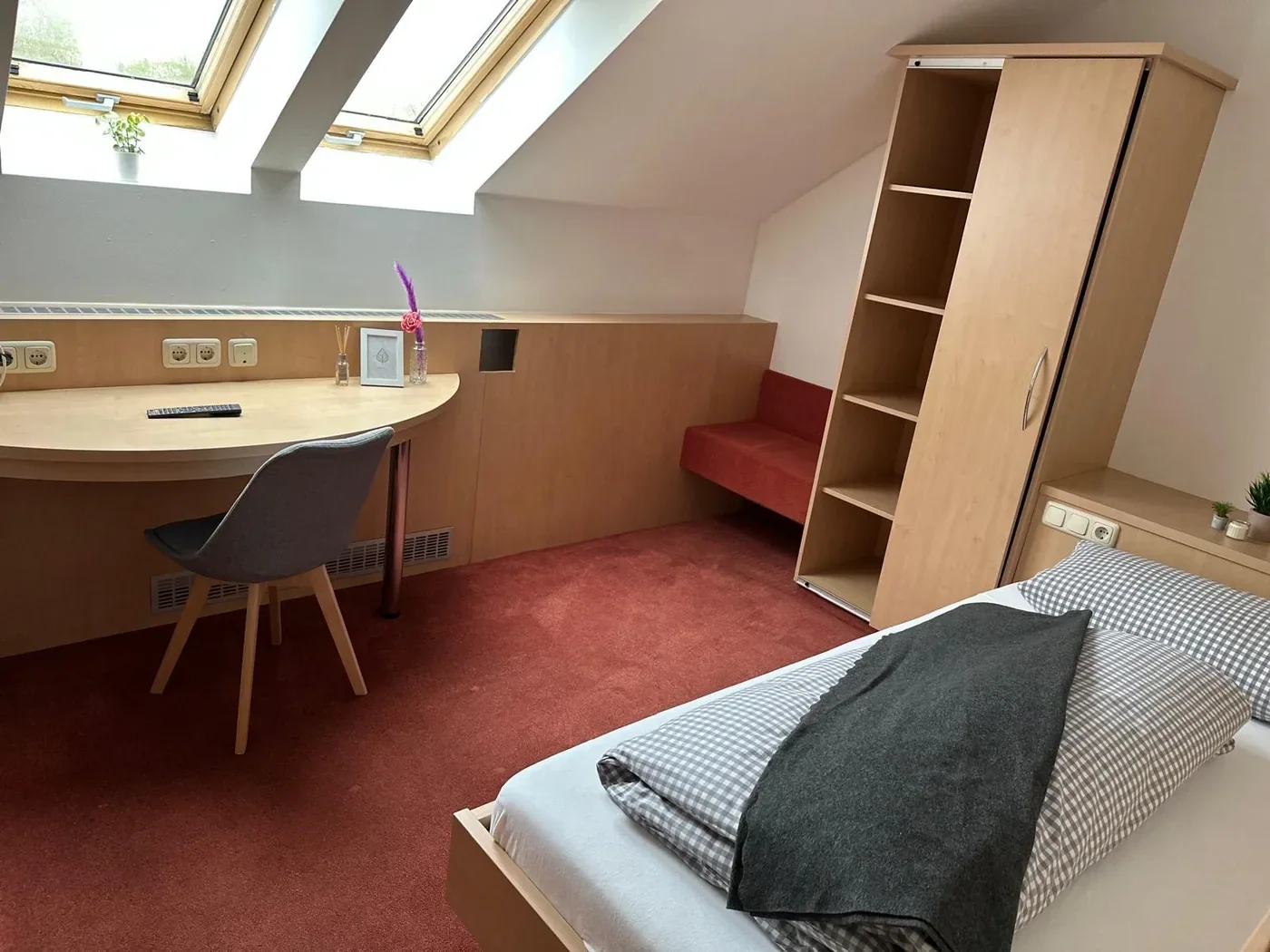 Doppelzimmer mit Doppelbett und Holzmöbeln
